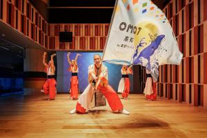 a group of people dancing on a stage with a flag at OMO7 Kochi by Hoshino Resorts in Kochi