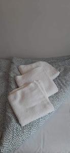 a pile of white towels sitting on a bed at Pokoje&Domki w Pobierowie in Pobierowo