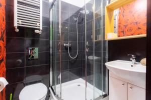 a bathroom with a shower and a toilet and a sink at Villa Superiq Victus Sopot Walk to the Pier by Noclegi Renters in Sopot