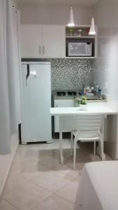 a kitchen with a white refrigerator and a white table at Cabo Frio Flats in Cabo Frio