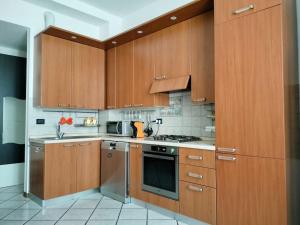 a kitchen with wooden cabinets and a stove top oven at Intero appartamento a Nord di Milano in Bresso