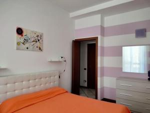 a bedroom with an orange bed and a dresser at Intero appartamento a Nord di Milano in Bresso