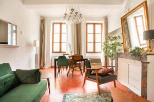 a living room with a green couch and a table at La Vaca superbe T3 Climatisation Wifi Netflix Coeur Historique in Béziers