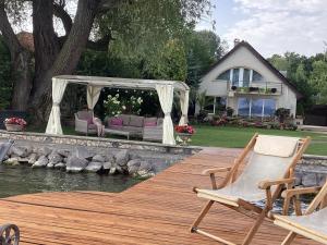 a deck with chairs and a gazebo on a house at Viktoria House in Balatonszárszó