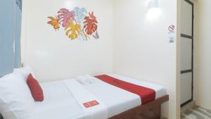 Postel nebo postele na pokoji v ubytování RedDoorz at Queens Hometel