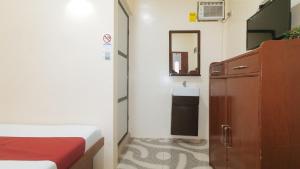 Postel nebo postele na pokoji v ubytování RedDoorz at Queens Hometel