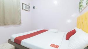 Postel nebo postele na pokoji v ubytování RedDoorz at Queens Hometel