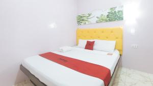 Postel nebo postele na pokoji v ubytování RedDoorz at Queens Hometel