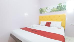 Postel nebo postele na pokoji v ubytování RedDoorz at Queens Hometel