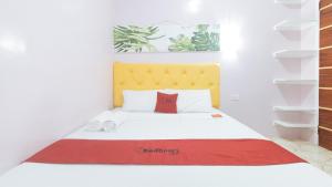 Postel nebo postele na pokoji v ubytování RedDoorz at Queens Hometel