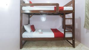 Postel nebo postele na pokoji v ubytování RedDoorz at Queens Hometel