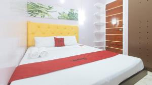 Postel nebo postele na pokoji v ubytování RedDoorz at Queens Hometel