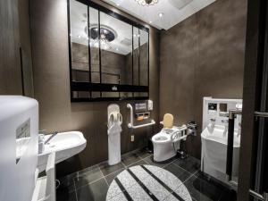 a bathroom with two sinks and a toilet and a mirror at APA Hotel AkihabaraSuehirocho Ekimae -Electric Town- in Tokyo