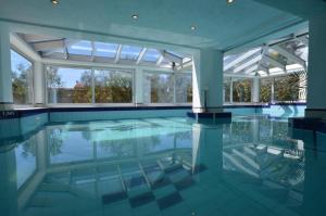 an indoor swimming pool with glass doors and windows at Apartments Ana Wellness S in Rovinj