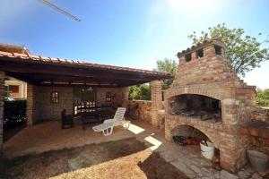 a patio with a stone fireplace and a chair at Apartments Ana Wellness S in Rovinj