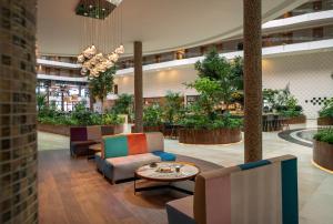 a lobby with chairs and a table and plants at Liberty Kuşadası in Kusadası
