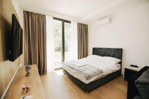 a bedroom with a bed and a large window at KS Apartments in Visoko
