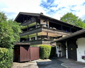 a large house with a fence in front of it at Achentalglück in Unterwössen