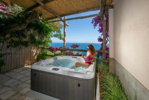 a woman sitting in a hot tub on a patio at Il Barilotto in Positano