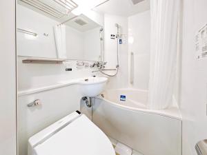 a white bathroom with a toilet and a sink at APA Hotel AkihabaraSuehirocho Ekimae -Electric Town- in Tokyo