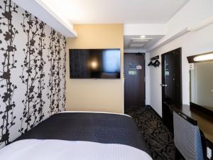 a hotel room with a bed and a flat screen tv at APA Hotel AkihabaraSuehirocho Ekimae -Electric Town- in Tokyo