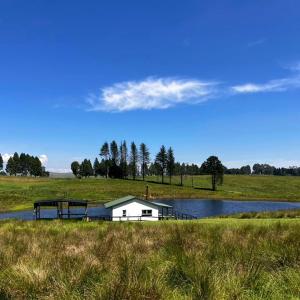 una casa en medio de un lago con un muelle en Oakridge Farm Cottage, en Nottingham Road
