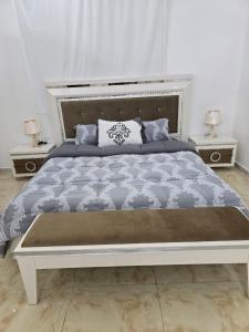 a bedroom with a large bed with two night stands at شقة مميزة غرفتين وصالة جيزان عوائل - وصول ذاتي in Jazan