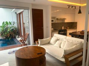 a living room with a white couch and a kitchen at Capung Smart Residence in Sanur