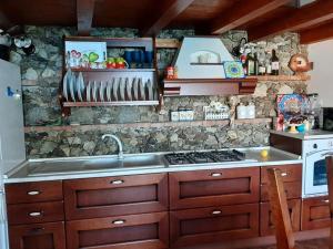a kitchen with a sink and a stone wall at villettina panoramica in Scilla