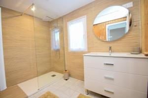 Un baño con ducha con lavabo y espejo. en Le Chalet Ma Neizh - 4 pers avec jardin, en La Richardais