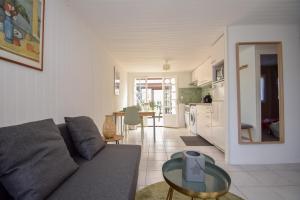 una sala de estar con un sofá y una mesa en Le Chalet Ma Neizh - 4 pers avec jardin, en La Richardais