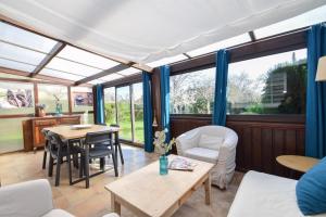 Un invernadero con mesa y sillas. en Le Chalet Ma Neizh - 4 pers avec jardin, en La Richardais 14 fotos más