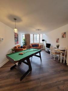 a living room with a ping pong table in it at Spacious Leicester Apt with Free Parking, Sleeps 6 in Leicester