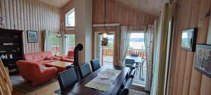 a dining room with a table and chairs and a living room at Matthias Hytte in Fevåg