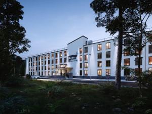 an exterior view of a white building at Platzhirsch Living in Kelsterbach