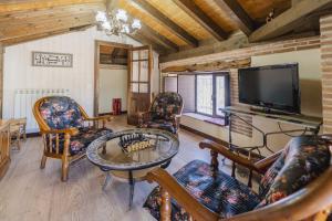 a living room with chairs and a table and a tv at El Rincón de Hornuez in Moral