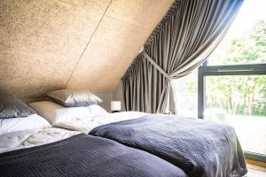 a bedroom with two beds next to a window at Cicha Woda - domki in Nowe Bagienice