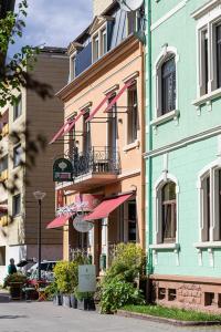a building with pink umbrellas on the side of it at Rosengarten in Kehl am Rhein +23 photos