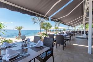 a restaurant on the beach with tables and chairs at Luxury Villa David's - two heated pool in Podstrana