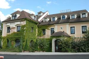 un edificio cubierto de hiedra en una calle en Hotel Bohemia Excellent en Klášterec nad Ohří