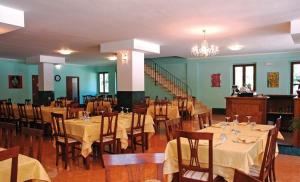 Vallo di NeraにあるHotel Ristorante Umbria Valnerinaのテーブルと椅子、シャンデリアのあるレストラン