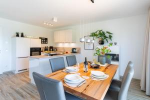 eine Küche und ein Esszimmer mit einem Holztisch und Stühlen in der Unterkunft Apartment "Meerzeit" - Oase am Haff in Garz