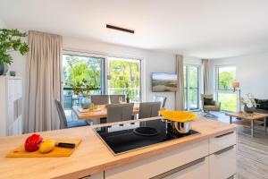 eine offene Küche und ein Esszimmer mit Tisch und Stühlen in der Unterkunft Apartment "Meerzeit" - Oase am Haff in Garz