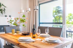 ein Esstisch mit Gläsern und einer Flasche Wein in der Unterkunft Apartment "Meerzeit" - Oase am Haff in Garz