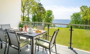ein Tisch und Stühle auf einem Balkon mit Blick auf das Meer in der Unterkunft Apartment "Meerzeit" - Oase am Haff in Garz