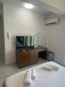 een slaapkamer met een bed en een dressoir met een tv bij Apartments Mosha in Ohrid