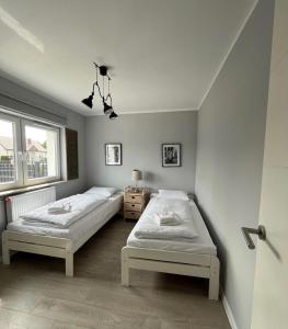 a bedroom with two beds and a window at CHILLIapartamenty - Dom w Grzybowie-W Brzozach in Grzybowo