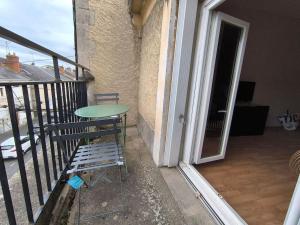 a table and a chair on a balcony at Welcome Home Parking, terrasse in Châteauroux