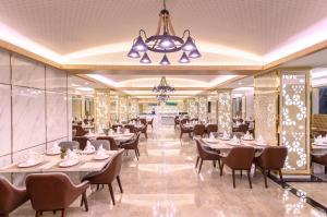 Un comedor con mesas y sillas y una lámpara de araña. en โรงแรม จอมเทียน ฮอลิเดย์ พัทยา, en Jomtien Beach
