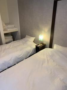 two beds in a small room with two bedsskirts at KAI 勝浦 Chiba in Katsuura